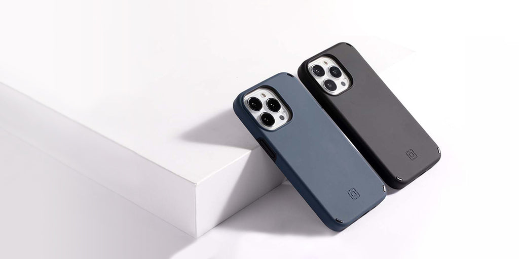 2 Incipio Duo cases in black and blue leaning against a ledge to show the back of the case