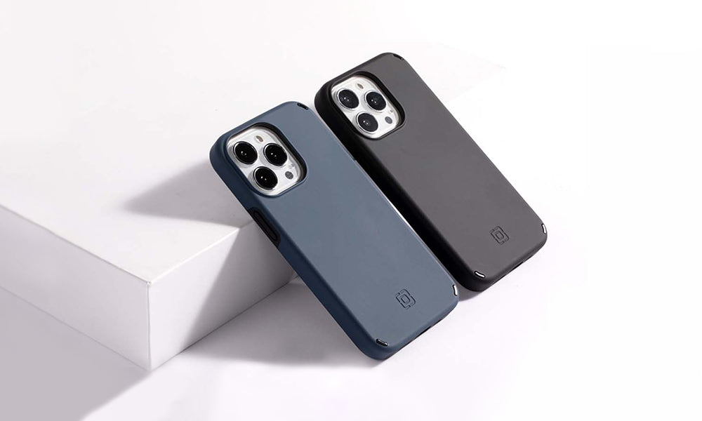 2 Incipio Duo cases in black and blue leaning against a ledge to show the back of the case