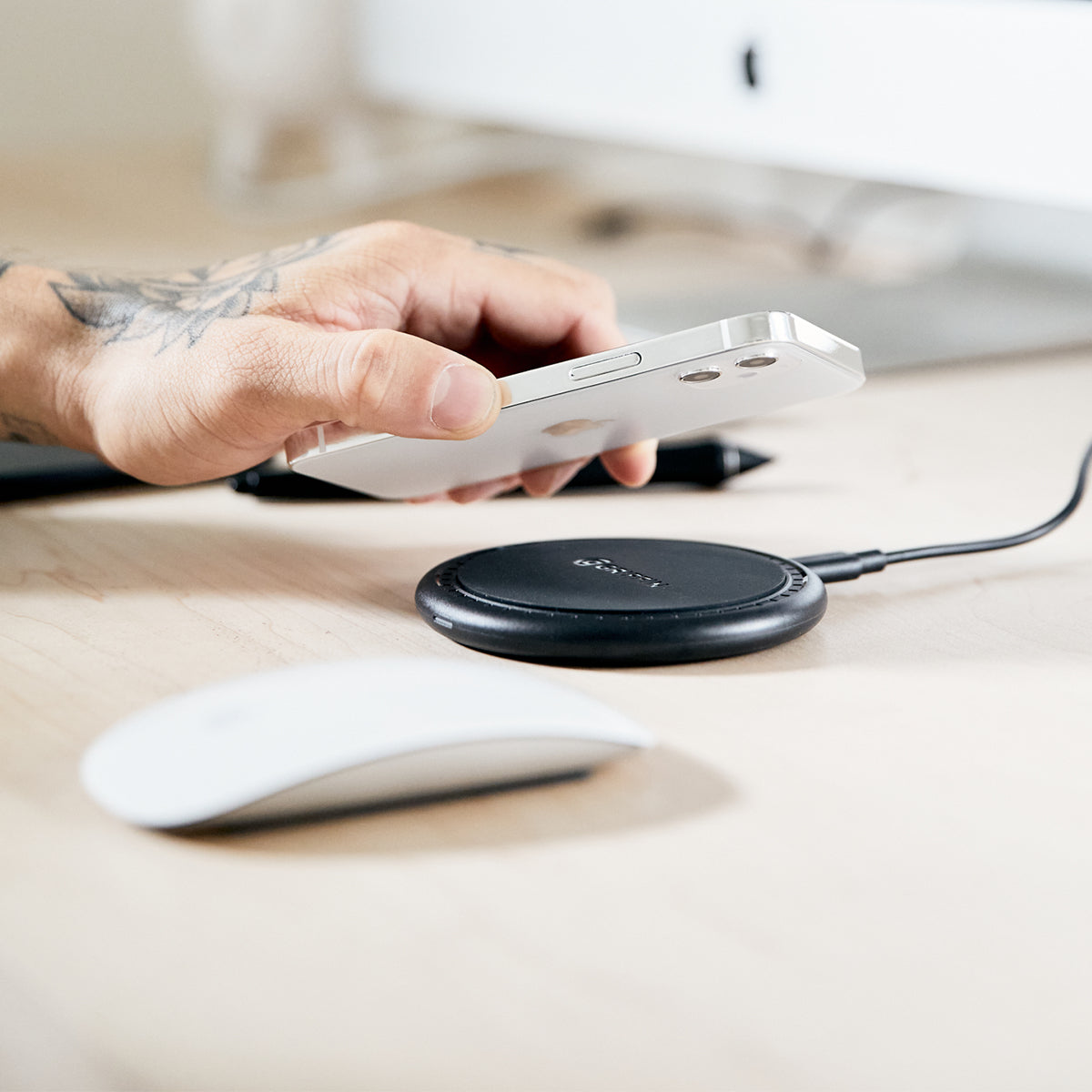 person placing an iphone on a griffin wireless charger